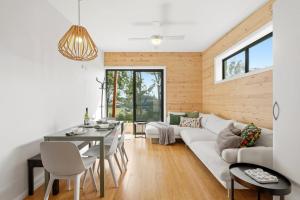 a living room with a white couch and a table at Hudsons Hideaway - Cosy Eco Cabin, Rainforest Walks in Dorrigo +32 photos