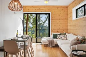 a living room with a white couch and a table at Hudsons Hideaway - Cosy Eco Cabin, Rainforest Walks in Dorrigo
