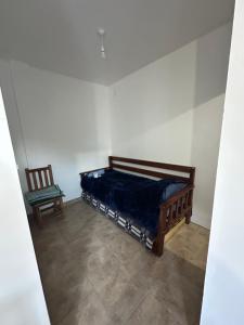 a small bedroom with a bed and a chair at Hospedaje ESMERALDA in Volcán