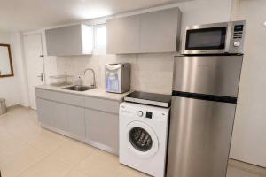 a kitchen with a washing machine and a microwave at Barak Royal Suites 20 sea view - ג'קוזי בחצר ומרפסות עם נוף לים in Eilat +5 photos