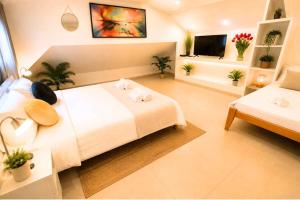 a large room with a bed and a tv at Barak Royal Suites 20 sea view - ג'קוזי בחצר ומרפסות עם נוף לים in Eilat