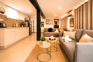 a living room with a couch and a kitchen at Barak Royal Suites 20 sea view - ג'קוזי בחצר ומרפסות עם נוף לים in Eilat
