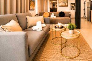 a living room with a couch and two tables with candles at Barak Royal Suites 20 sea view - ג'קוזי בחצר ומרפסות עם נוף לים in Eilat