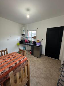 a room with a kitchen with a table and a desk at Hospedaje ESMERALDA in Volcán