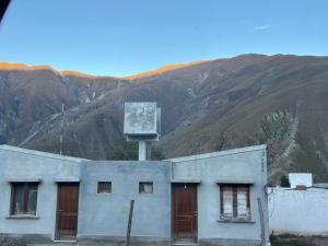 a building in front of a mountain at Hospedaje ESMERALDA in Volcán +3 photos
