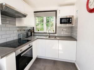 a white kitchen with a sink and a window at Cornwall Cosy Bungalow in Hayle