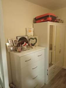 a white cabinet with photos and a suitcase on top at Cozy stay in Dublin