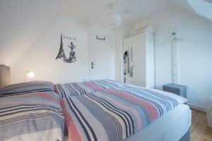 バート・ザルツフレンにあるTal-Residenzのベッドルーム1室(ストライプ毛布付きのベッド1台付)