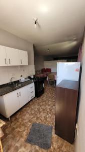 a kitchen with white cabinets and a refrigerator at Monoambiente La Falda in La Falda
