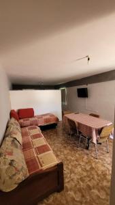 a room with beds and tables and a flat screen tv at Monoambiente La Falda in La Falda