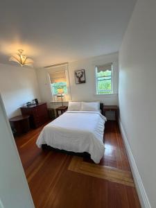 a bedroom with a white bed and two windows at Van Guesthouse in Vancouver +33 photos