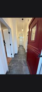 a hallway with a red door and a hallway with a hallwayngth at The Old Post Office Cottage in Castlebar +58 photos