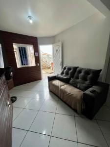 a living room with a couch sitting on a tile floor at 11-Casa espaçosa com garagem e Wi-Fi in São Leopoldo