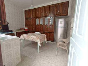 a kitchen with a table and a refrigerator at Dar arbi in Kelibia +3 photos