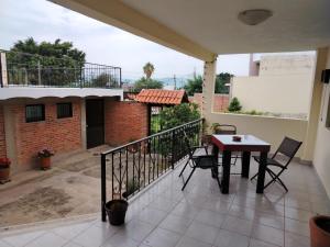 a patio with a table and chairs on a balcony at Casa Lago de Luz in San Juan Cosalá