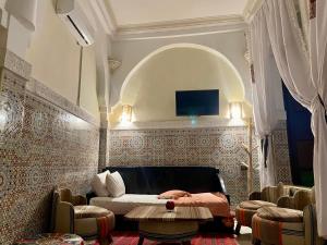 a bedroom with a bed and a tv on a wall at Riad Olivier Marrakech medina in Marrakesh