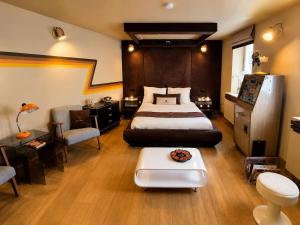 a bedroom with a bed and a couch and a table at Chez Claude - Retro Chic Suite in Charleroi +8 photos