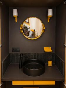 a bathroom with a black sink and a mirror at Chez Claude - Retro Chic Suite in Charleroi