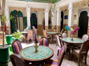 a room with tables and chairs with flowers on them at Riad Olivier Marrakech medina in Marrakesh