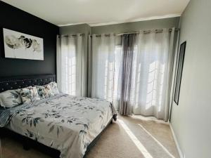 a bedroom with a bed and a large window at The Grand Maple Residence in Brampton +9 photos
