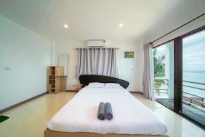 a bedroom with a bed with a pair of shoes on it at Gao Lighthouse Phala Beach in Ban Phala