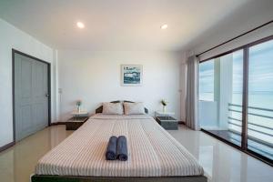 a bedroom with a bed with two pairs of shoes on it at Gao Lighthouse Phala Beach in Ban Phala
