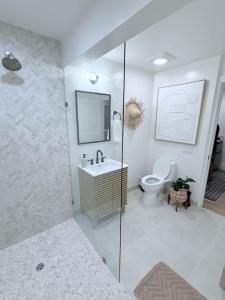 a bathroom with a toilet and a sink and a shower at Kona Hang Loose Studio in Kailua-Kona