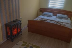 a bedroom with a bed and a fire place at Kovaci Garden House in Sarajevo