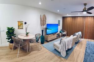 a living room with a tv and a table and chairs at Kona Hang Loose Studio in Kailua-Kona