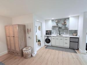 a kitchen with white cabinets and a washer and dryer at Kona Hang Loose Studio in Kailua-Kona