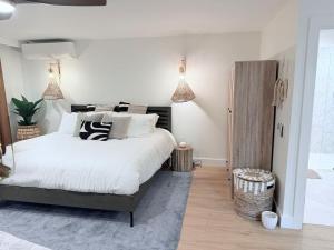 a bedroom with a large bed with white sheets and pillows at Kona Hang Loose Studio in Kailua-Kona