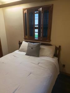 a white bed with two pillows and a window at Dubuque's Hidden Gem! in Dubuque