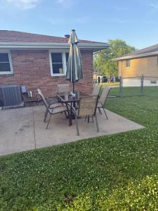 a patio with a table with an umbrella and chairs at Dubuque's Hidden Gem! in Dubuque