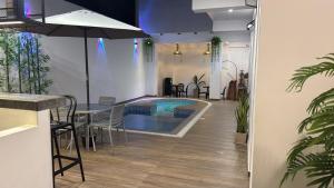 a swimming pool in a room with a table and chairs at Hotel El Galeón in Paracas