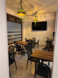 a dining room with tables and chairs and a flat screen tv at Hotel El Galeón in Paracas