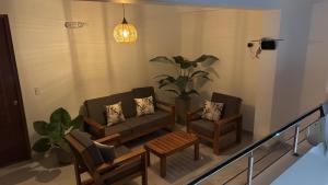 a living room with a couch and two chairs at Hotel El Galeón in Paracas