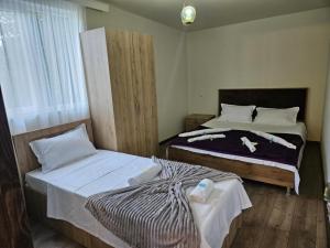 a bedroom with two beds and a window at NIISS house in Akhaltsikhe