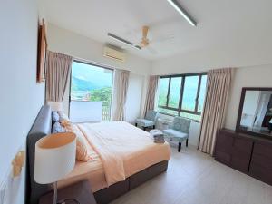 a bedroom with a bed and a couch and windows at By The Sea - UBTS SMART ENTERPRISE in Batu Ferringhi +123 photos
