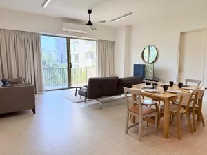 a living room with a table and a couch at By The Sea - UBTS SMART ENTERPRISE in Batu Ferringhi