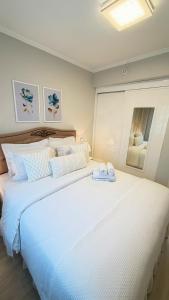 a large white bed with two white shoes on it at Ibirapuera Privilege - Suíte Deluxe Moema in São Paulo