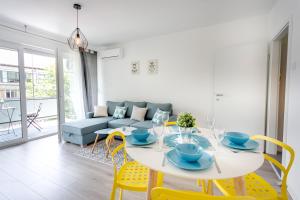 a dining room with a white table and yellow chairs at Go2Zagreb in Zagreb