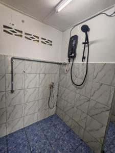 a shower in a bathroom with a phone on the wall at STUDIO HOMESTAY Arjuna in Pantai Remis