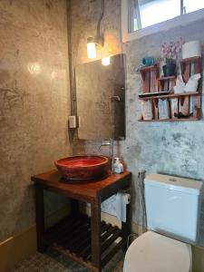 a bathroom with a bowl sink and a toilet at Nan De Panna Homestay in Nan +49 photos