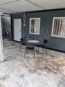 a room with a table and chairs in it at STUDIO HOMESTAY Arjuna in Pantai Remis