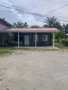 a small blue house with a red roof at STUDIO HOMESTAY Arjuna in Pantai Remis