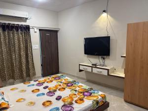 a bedroom with a bed and a tv in a room at Neem Tree Farm Stay in Ujjain
