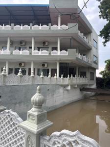 a building with a pool of water in front of it at Neem Tree Farm Stay in Ujjain