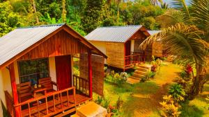 a group of cottages in a forest with trees at Haris Homestay & Cottages in Senaru