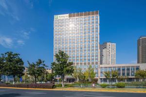 a tall building in the middle of a city at Holiday Inn Kunshan by IHG in Kunshan