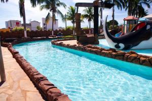 a pool at a resort with a dolphin slide at ARARAS Apart Hotel - CTC in Caldas Novas